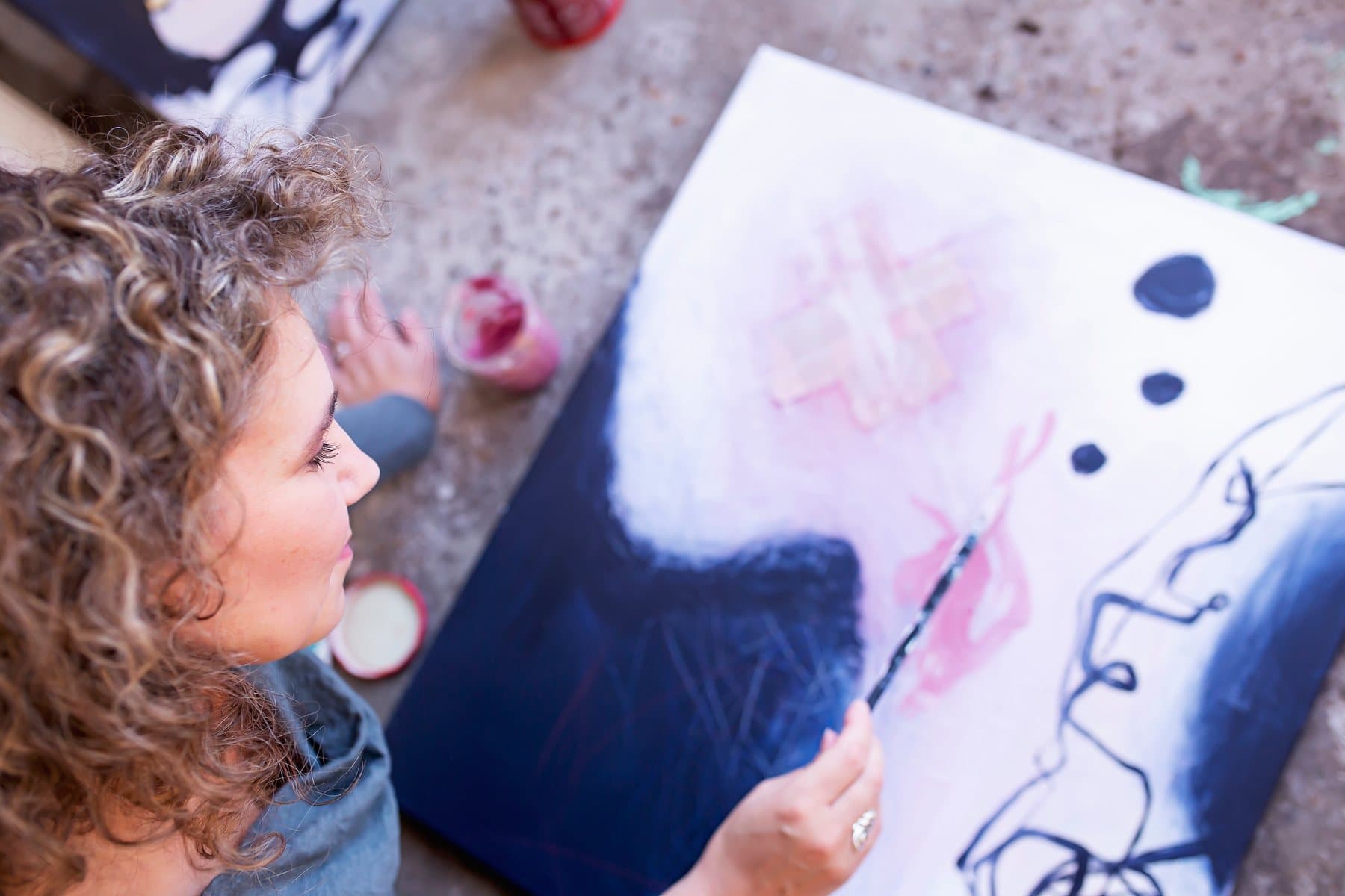 Mieke Fleurackers painting on a canvas, seen from above